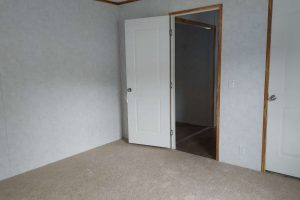 An open door to a bedroom with carpet on floor