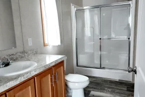 Model 24806 large bathroom featuring a stand up shower, vanity, and toilet